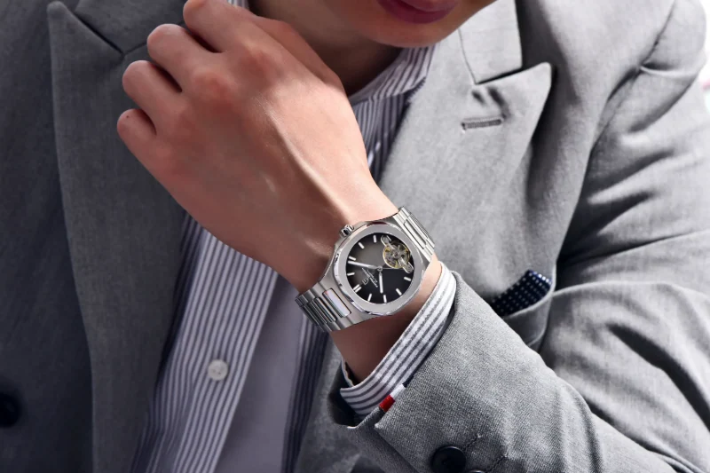 Professional shot of a man wearing a Pagani Design black dial skeleton watch with a grey blazer and suit.