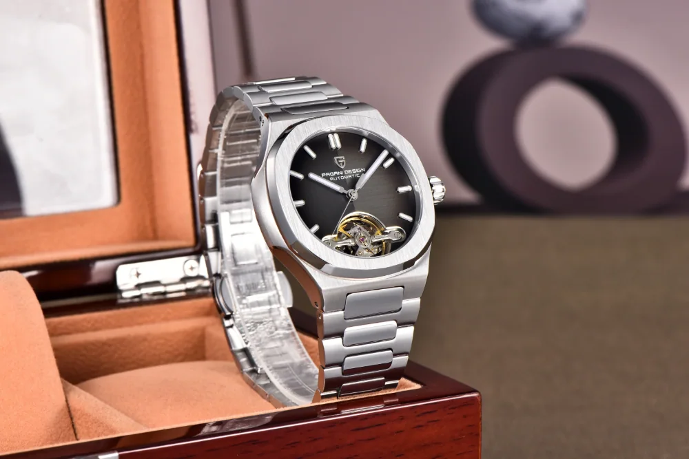 An angled view of the Pagani Design silver mechanical watch with a black skeleton dial in a luxury box.