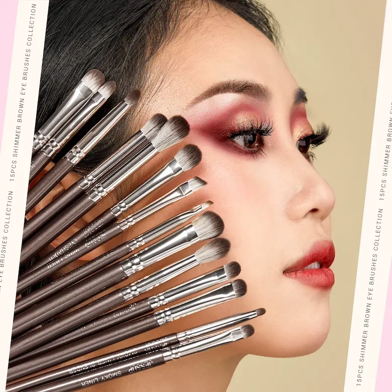 A beautiful model showing a dramatic shimmer brown eyeshadow look while holding professional cosmetic tools against her face.