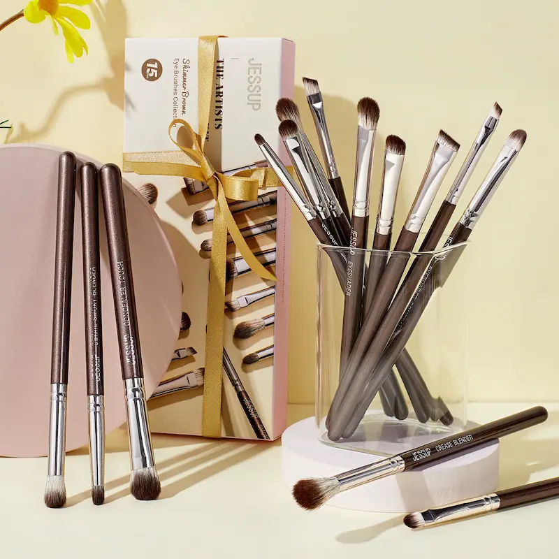Jessup Eye Makeup Brushes arranged neatly in a glass holder next to their original elegant gift packaging box.