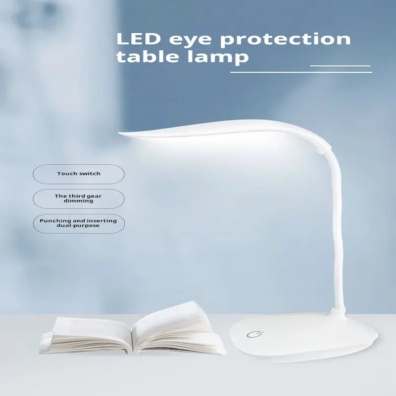 White LED eye protection lamp placed next to an open book on a table with a clean blue background