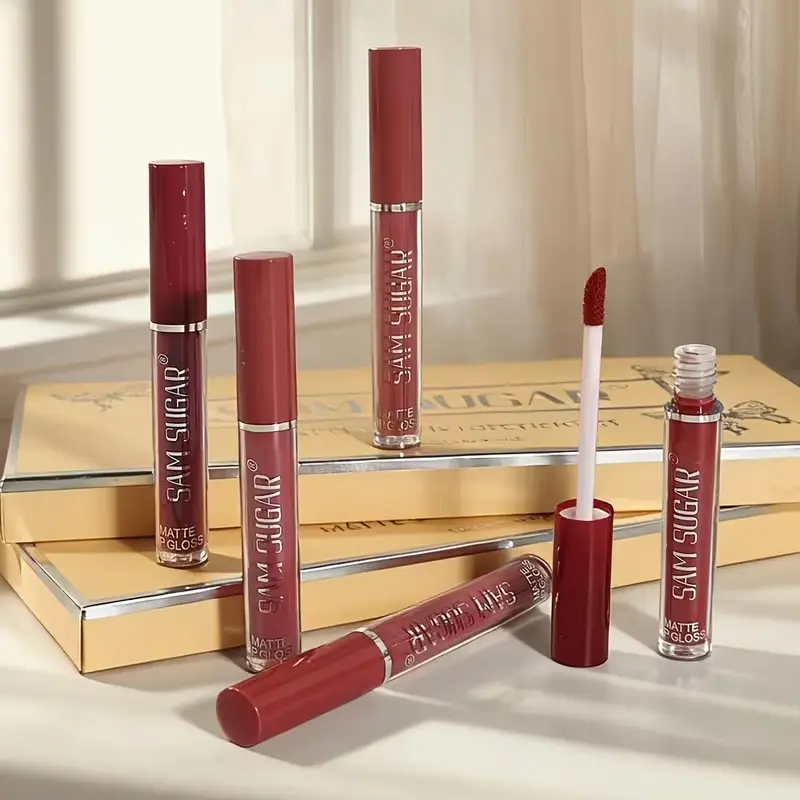 Aesthetic display of SAM SUGAR matte liquid lip gloss tubes on a beige background.