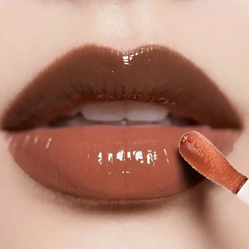 Applying shiny Beauty Glazed glow lip oil over a matte brown lip liner base for a plump finish.