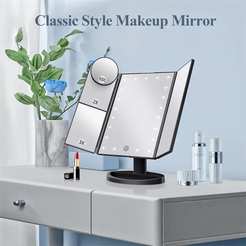 Classic style black trifold vanity mirror with built-in lights placed on a modern white dressing table.