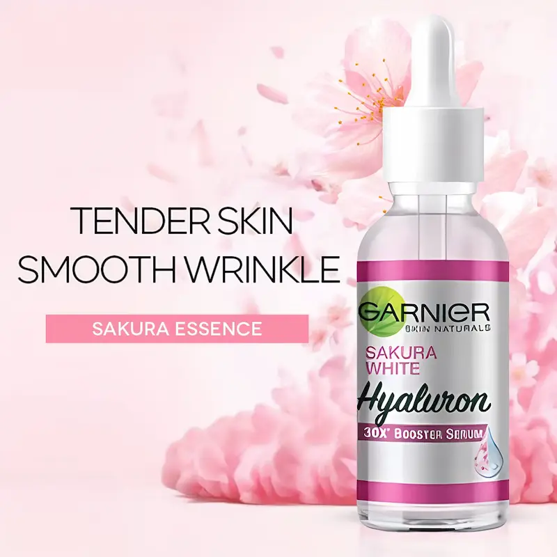 Garnier Sakura Glow booster serum bottle displayed against a pink floral background.