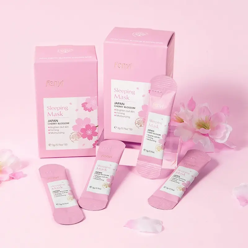 Individual packaging sachets and boxes of Fenyi Japan Cherry Blossom Sleeping Mask on a pink background.