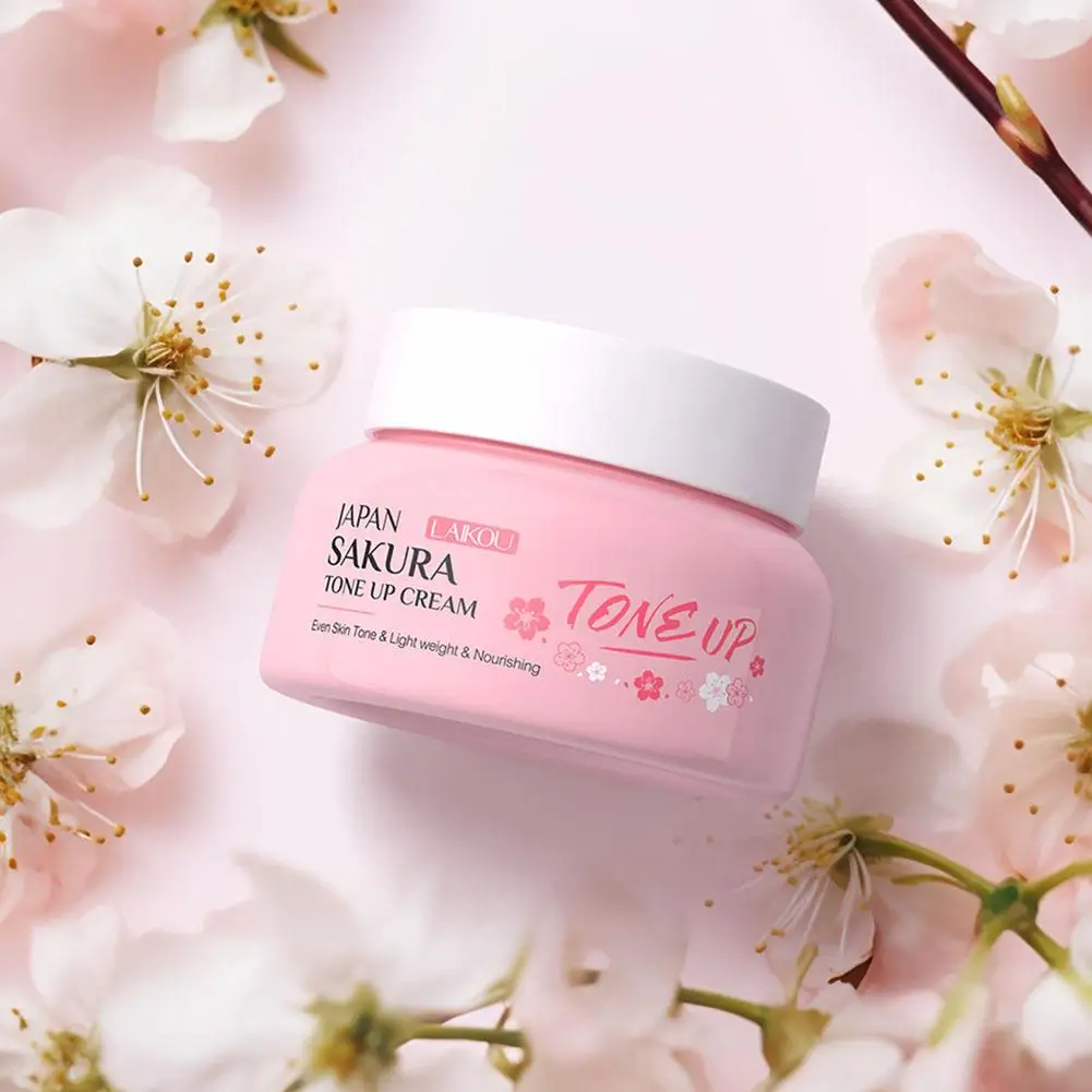 Close-up of LAIKOU Sakura Tone Up Cream pink jar on a floral background.