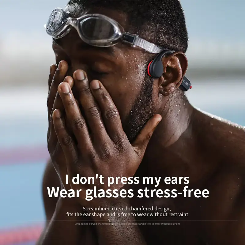 A man wearing swimming goggles and the bone conduction headset, showing it doesn't press against the ears.
