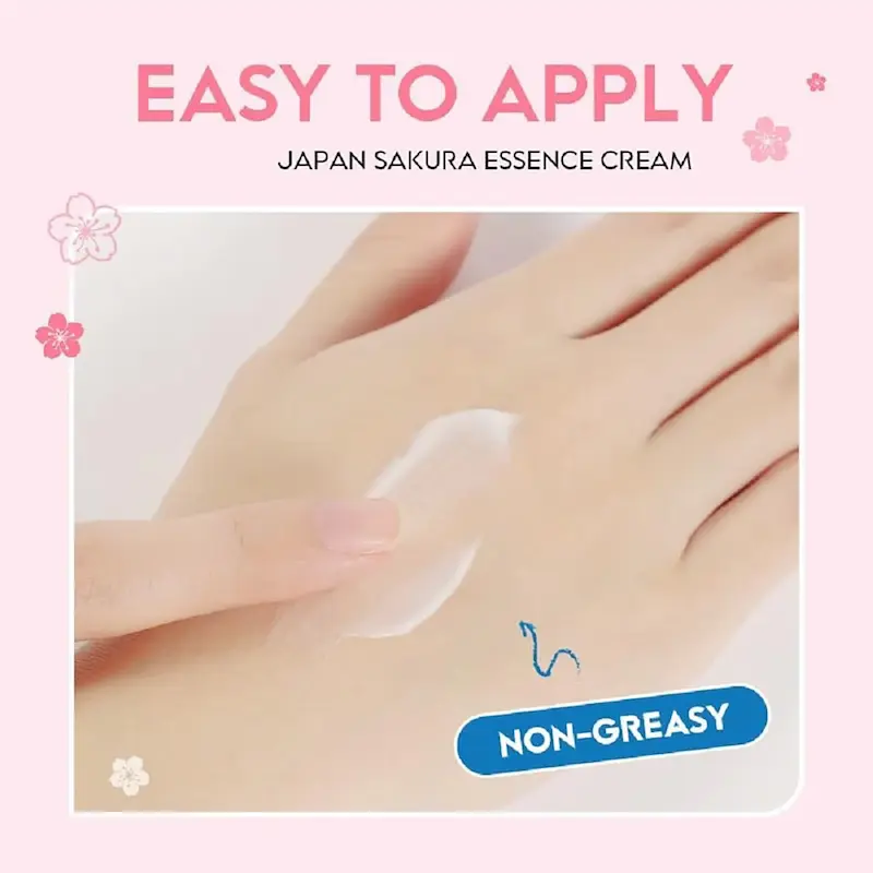 A hand showing the smooth white texture of the Japan Sakura Essence Cream being spread easily.