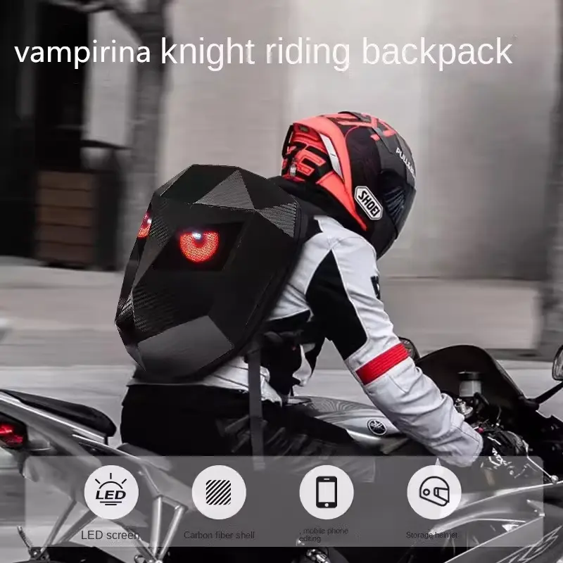 A biker on a sport bike carrying a geometric black hard-shell bag with red glowing eyes.