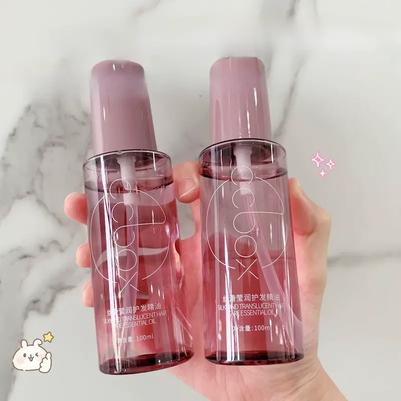 Two bottles of CCBOX silky and translucent hair care formula against a marble background.