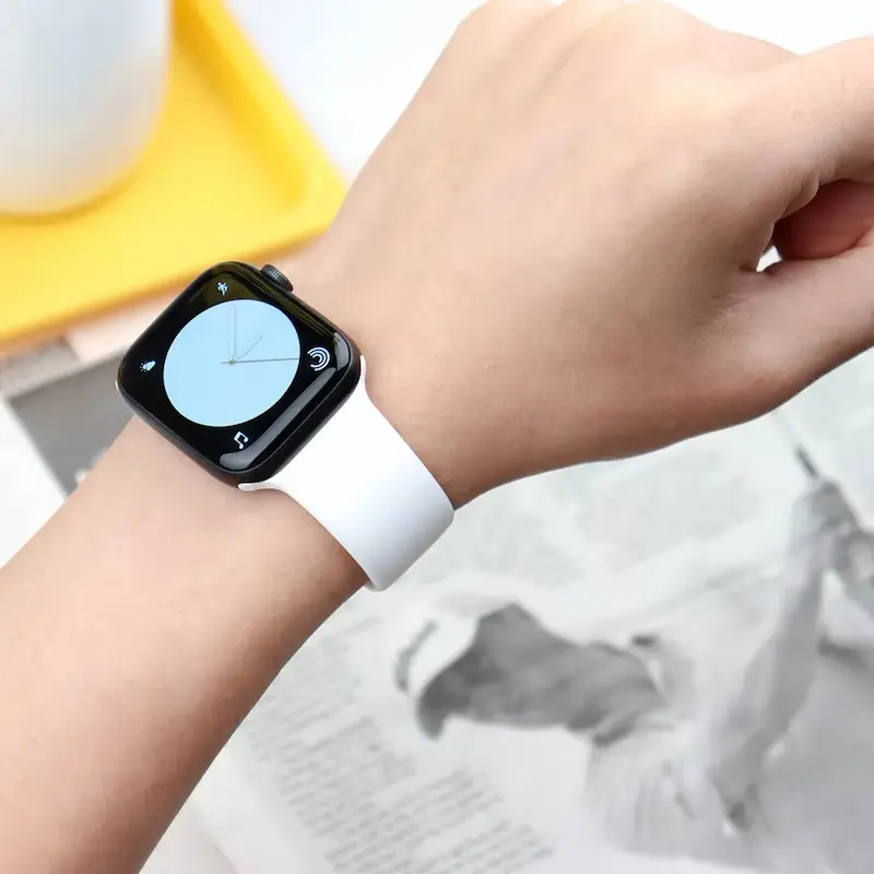 A classic white silicone Apple Watch band worn during daily activities.