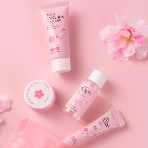 Top-down view of LAIKOU Sakura skincare essentials including essence cream, toner, and cleanser on a soft pink aesthetic background.